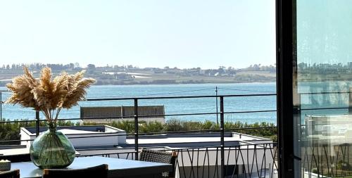 a balcony with a table and a view of the water at Villa Au Rythme Des Marées in Carantec