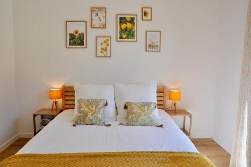 a bedroom with a white bed with two lamps at Villa Au Rythme Des Marées in Carantec