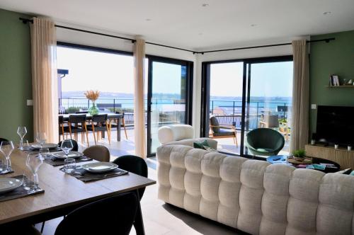 - un salon avec un grand canapé et une table à manger dans l'établissement Villa Au Rythme Des Marées, à Carantec