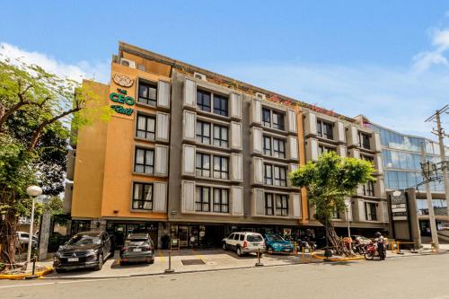 a large building with cars parked in a parking lot at CEO Flats in Manila
