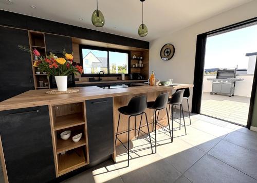 a kitchen with a island with bar stools at Villa Au Rythme Des Marées in Carantec