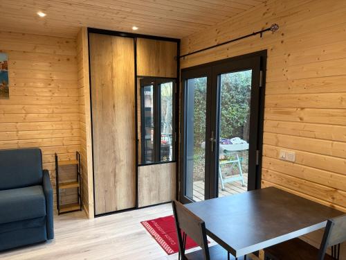 - une salle à manger avec une table dans une pièce dotée de murs en bois dans l'établissement La Case à Jo II, à Balaruc-les-Bains