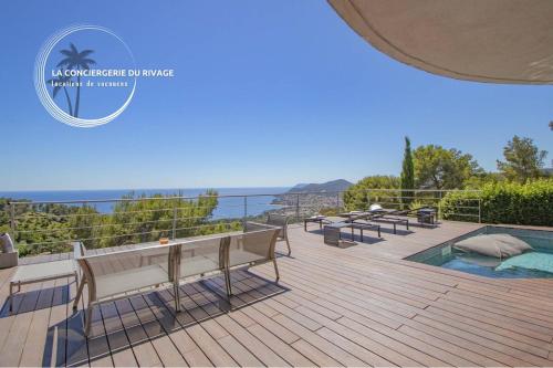 une terrasse avec bancs et vue sur l'océan dans l'établissement Villa Héméra - Vue Panoramique - Piscine - Jacuzzi, à Carqueiranne