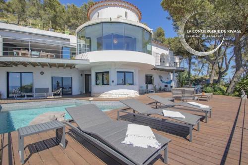 une grande maison avec une piscine et une maison dans l'établissement Villa Héméra - Vue Panoramique - Piscine - Jacuzzi, à Carqueiranne