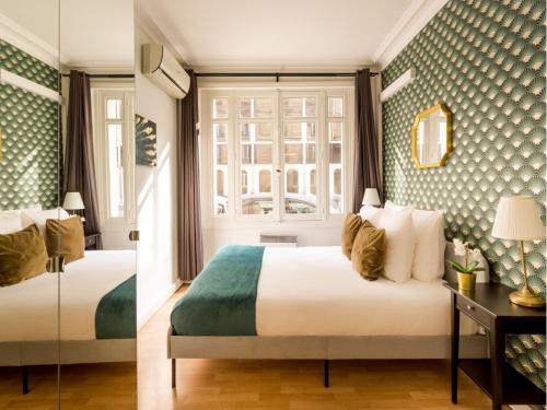une chambre d'hôtel avec deux lits et une fenêtre dans l'établissement Merveil - Family Suite - Champs Elysees - Mollien, à Paris