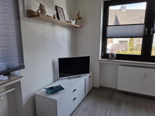 a living room with a tv on a white dresser at FeWo kleine Auszeit Höxter in Höxter