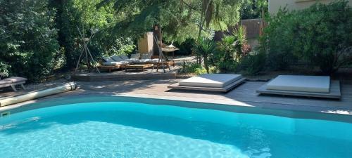 une piscine avec des chaises longues à côté d'une maison dans l'établissement le jardin, à Draguignan