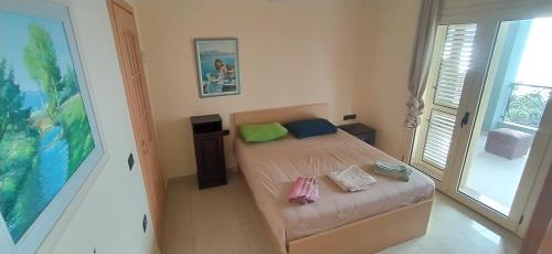 a small bedroom with a bed and a window at Pinwheel Hostel Vlora & Rooftop Bar in Vlorë