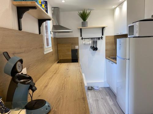 Il comprend une petite cuisine avec un réfrigérateur et du parquet. dans l'établissement Cottage au calme dans les dunes, à Le Touquet-Paris-Plage