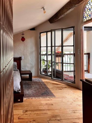 une chambre avec un lit et de grandes fenêtres dans l'établissement Chez Gui & Jisuk T6 Maison Dam Dam Léojac, à Léojac