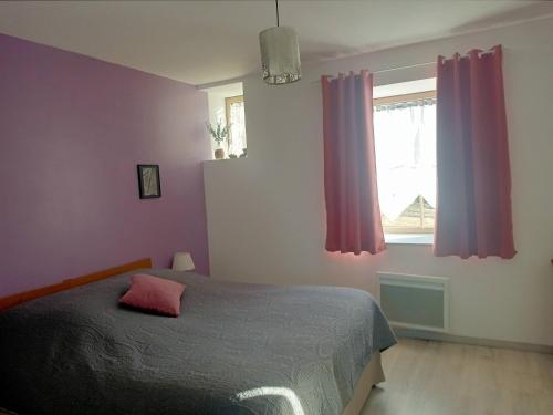a bedroom with a bed and a window with purple curtains at Au Mont & Merveilles in Sartilly