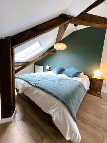 une chambre avec un grand lit avec des draps bleus dans l'établissement Suite Isidore - 2 pers Esprit cabane urbaine, à Charleville-Mézières