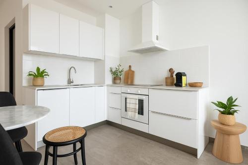 une cuisine avec des armoires blanches et une table dans l'établissement French Dolce Vita near Croisette, à Cannes