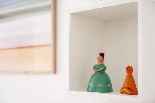 a toy figurine of a woman standing on a shelf next to a window at Corte Curatolo in Martano