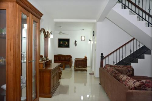 a living room with a couch and a staircase at Belmont Villa - Free Airport Shuttle Service in Negombo