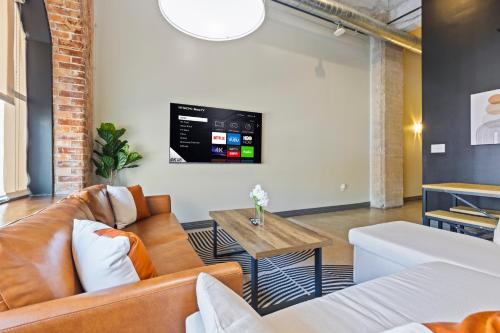 a living room with a couch and a tv on the wall at Luxury - Kay Bailey - Free Parking in Dallas