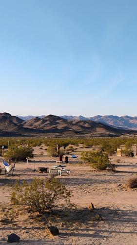a field with tables and chairs in the desert at Simply Camping in Hidden River