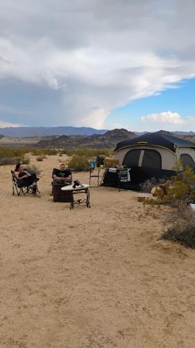 a group of people sitting in chairs next to a tent at Simply Camping in Hidden River