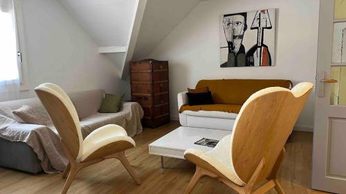 Una sala de estar con dos sillas y un sofá. en Apartment near Lake Annecy, en Menthon-Saint-Bernard