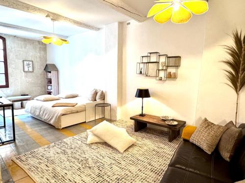 un salon avec un lit et un canapé dans l'établissement Maison rénovée avec Clim et loggia - arles centre, à Arles
