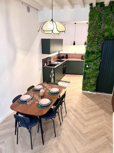 une cuisine et une salle à manger avec une table et des chaises en bois dans l'établissement Maison rénovée avec Clim et loggia - arles centre, à Arles