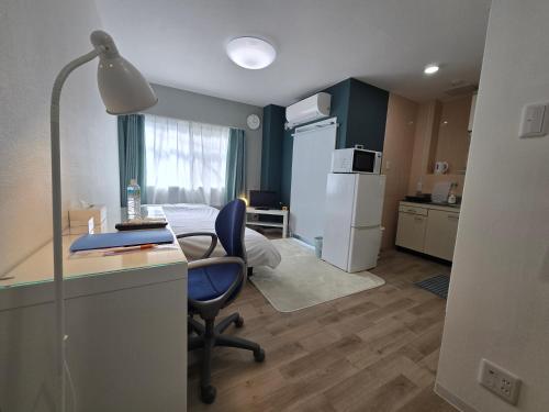 a room with a desk and a chair and a kitchen at SABBATH uzumasa 201 in Kyoto