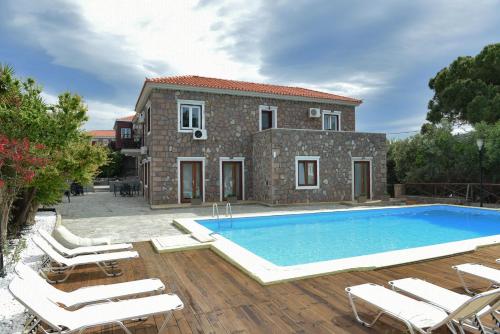a villa with a swimming pool in front of a house at PETRINO Hotel in Mithymna