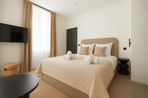 - une chambre avec un grand lit blanc et une télévision à écran plat dans l'établissement Croisette Cosy Studio, à Cannes