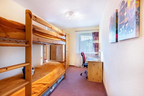 a bedroom with two bunk beds and a desk at Ferienwohnungen Tannengeflüster in Ühlingen-Birkendorf