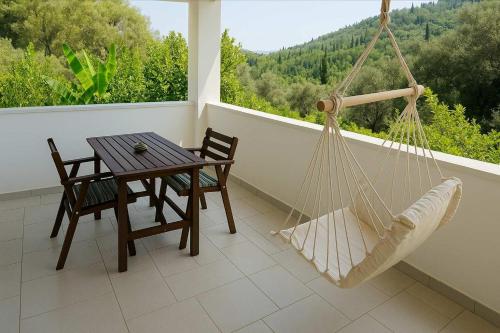 a porch with a hammock and a table and chairs at Serenity Suite in Corfu - Escape to Paradise in Kouspádes