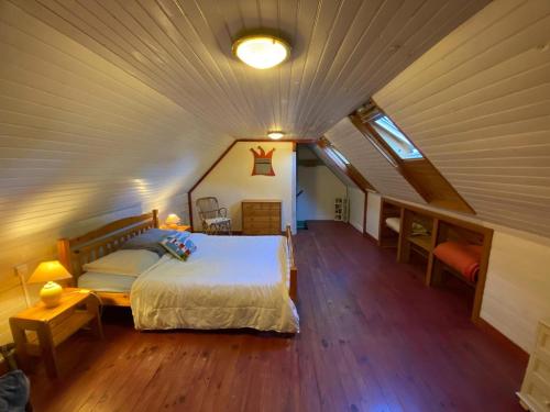 une chambre avec un grand lit dans un grenier dans l'établissement gite du mouton pêcheur, à Penmarcʼh