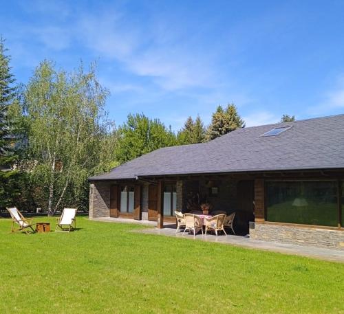 un edificio con un tavolo e delle sedie in un cortile di El Refugi de Tartera, Cerdanya a Prats i Sansor
