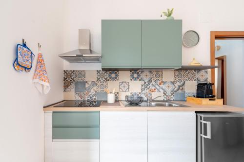 a kitchen with white cabinets and a sink at Corte Curatolo in Martano