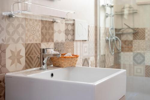 a white sink in a bathroom with a shower at Corte Curatolo in Martano