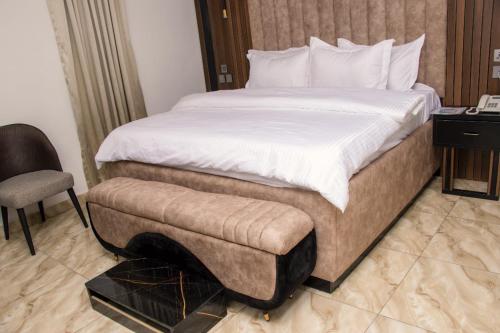 a hotel room with a bed and a chair at American Courts Hotel in Lagos