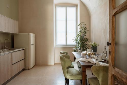 a kitchen with a table with chairs and a refrigerator at Pavillon Suite in Peschiera del Garda