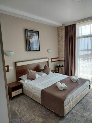 a bedroom with a large bed with two towels on it at Hotel Laguna in Mangalia