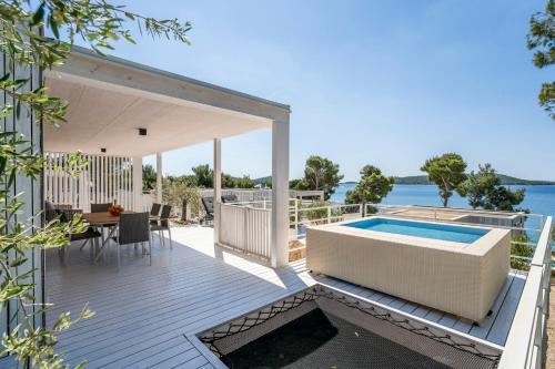 an outdoor deck with a swimming pool and a house at Victorie Villa Buqez in Drage