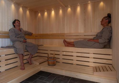 two men are sitting in a sauna at Hôtel de la Plage in Plonévez-Porzay