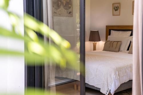 a bedroom with a bed with white sheets and a lamp at Villa Sharma 5* : Détente et bien être. in Saint-Pierre