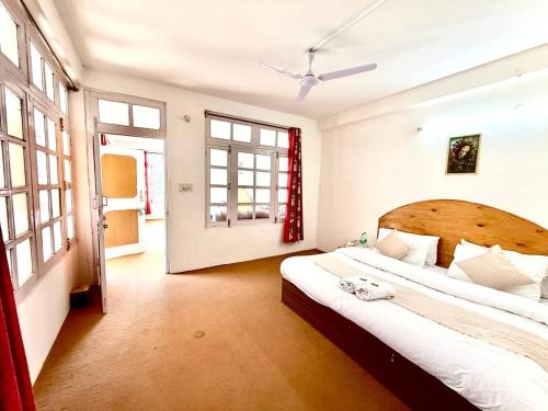 a bedroom with a large bed and a large window at Hotel The Premium Villa Old Manali View in Manāli