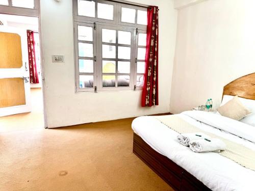 a bedroom with a bed and a window at Hotel The Premium Villa Old Manali View in Manāli