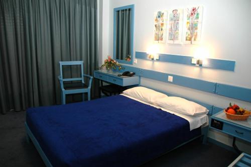 a bedroom with a blue bed and a desk and a chair at Amalia in Thessaloniki