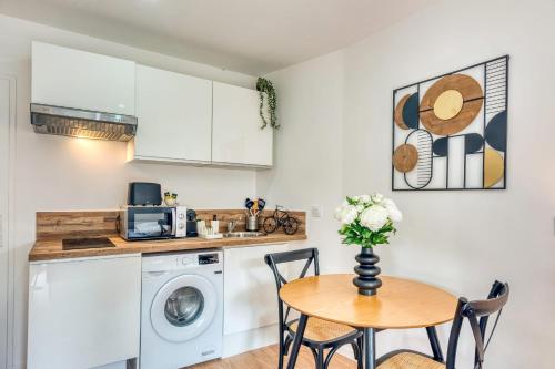 une cuisine avec une table et une machine à laver dans l'établissement Le Petit Atelier - Climatisé extérieur - Jean Macé, à Lyon