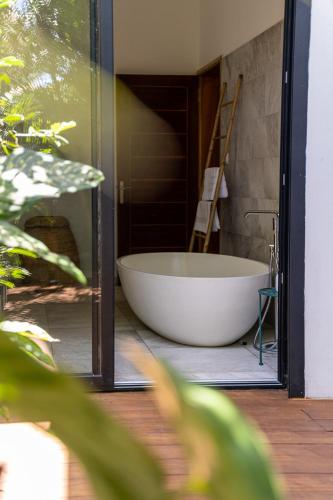 a large white bath tub sitting in a bathroom at Villa Sharma 5* : Détente et bien être. in Saint-Pierre