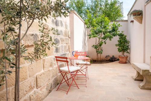 a table and chairs in a courtyard with trees at Corte Curatolo in Martano