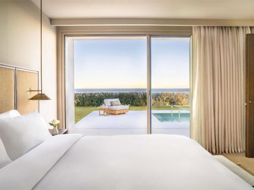 a bedroom with a large bed and a large window at Fairmont La Hacienda Costa del Sol in Alcaidesa