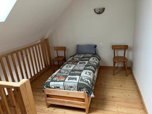 une chambre avec un lit et deux chaises dans l'établissement Le Bijou, à Besançon