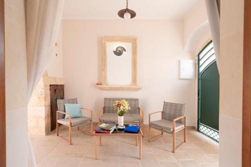 a living room with chairs and a table and a window at Corte Curatolo in Martano