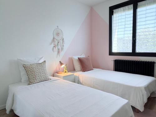 une chambre avec deux lits et une fenêtre dans l'établissement Villa Lumière - Confort, spa, piscine & babyfoot, à Beynost